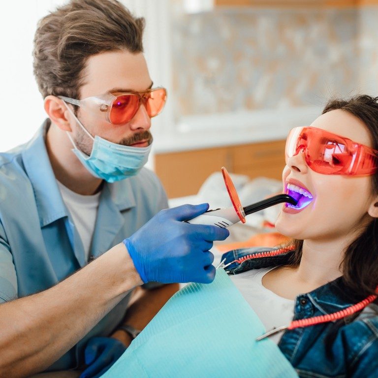 medicine-dentistry-healthcare-concept-dentist-using-dental-curing-uv-lamp-teeth-patient (Medium)